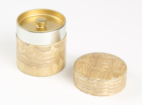 タモ材の玉杢を薄くスライスしスチール缶に張り付けた茶筒になります。タモ在玉杢特有の杢目の美しさをお楽しみ下さいませ。